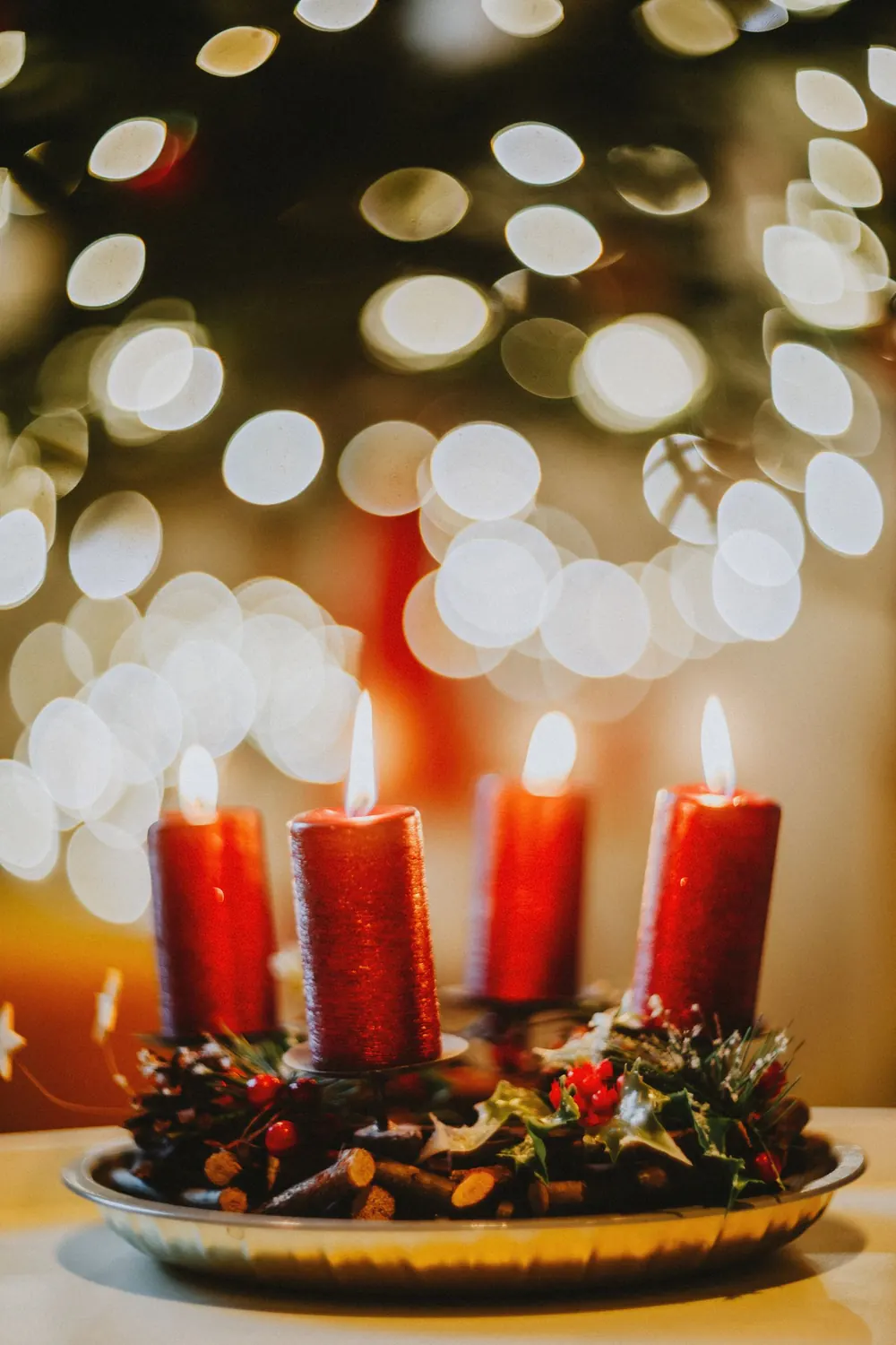 Cozy festive candle arrangement with decorative bokeh lights, capturing the warmth of the holiday season.
