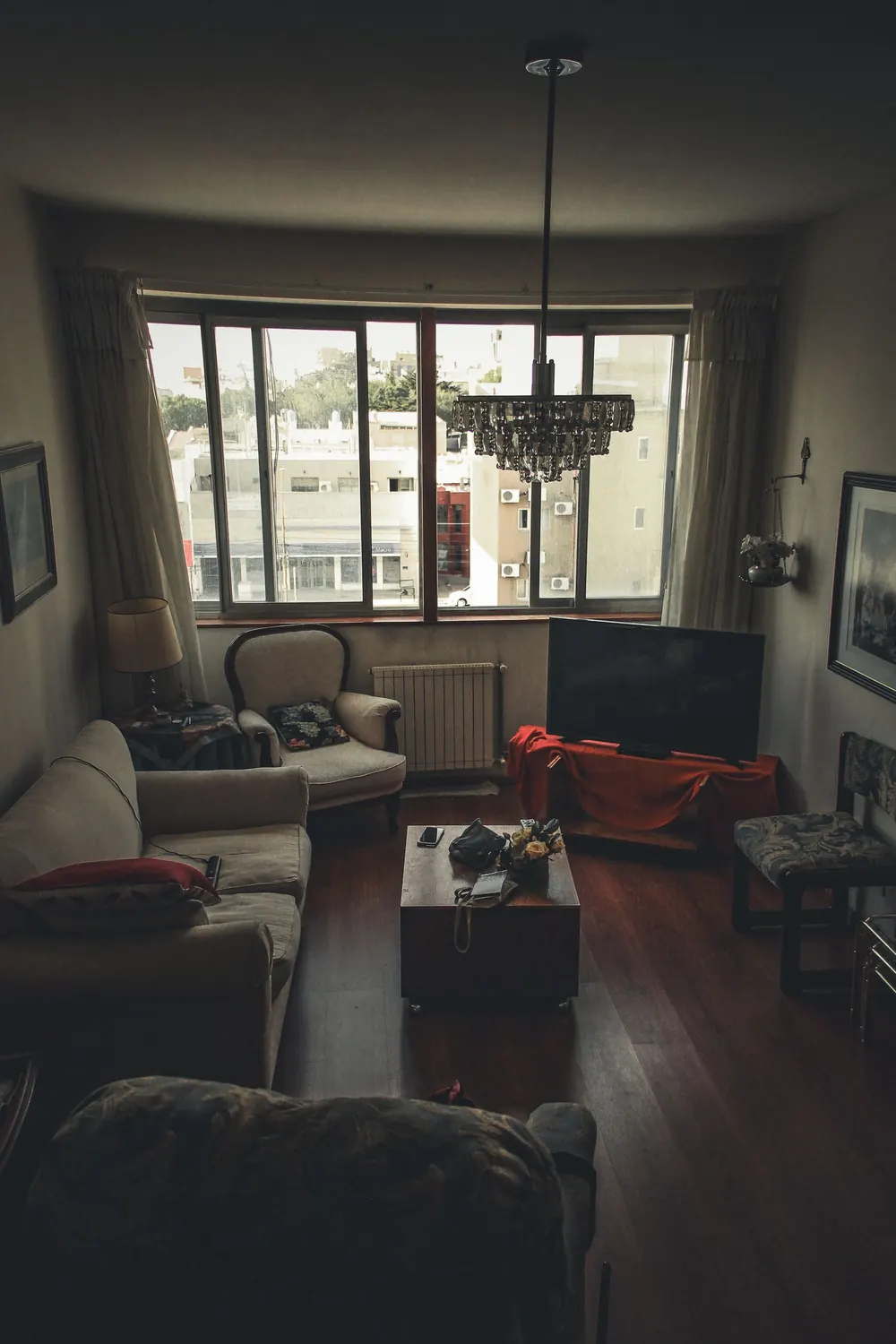 Warm and cozy living room featuring vintage furniture and a large window view.