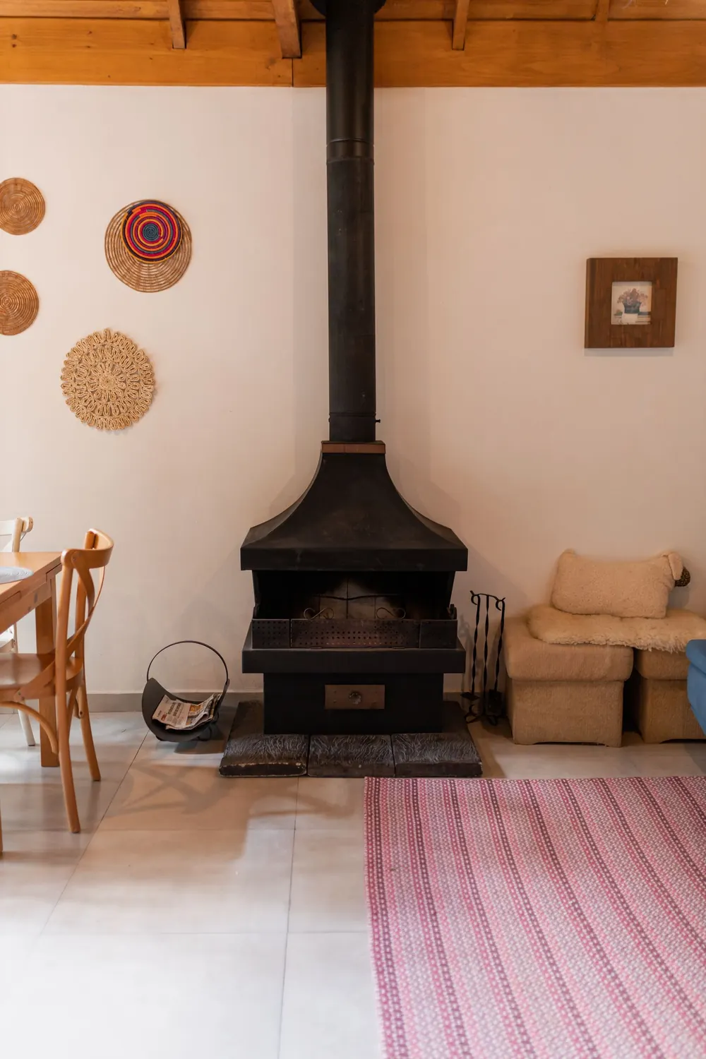 Warm and inviting rustic living room featuring a black metal fireplace and cozy decor.