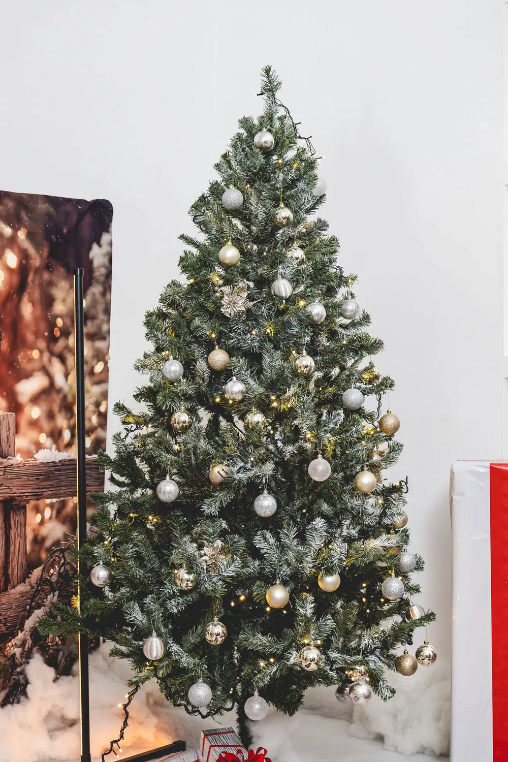A beautifully adorned Christmas tree with golden and silver ornaments indoors.