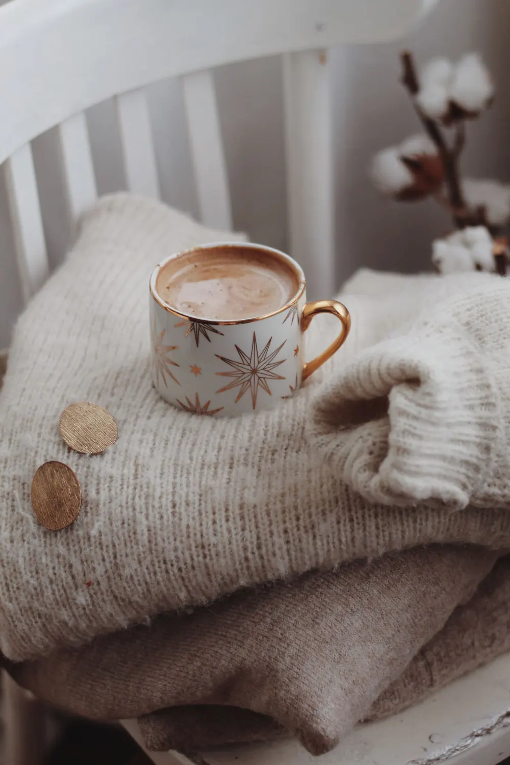 Warm cup of cocoa on a soft sweater for a cozy winter vibe.